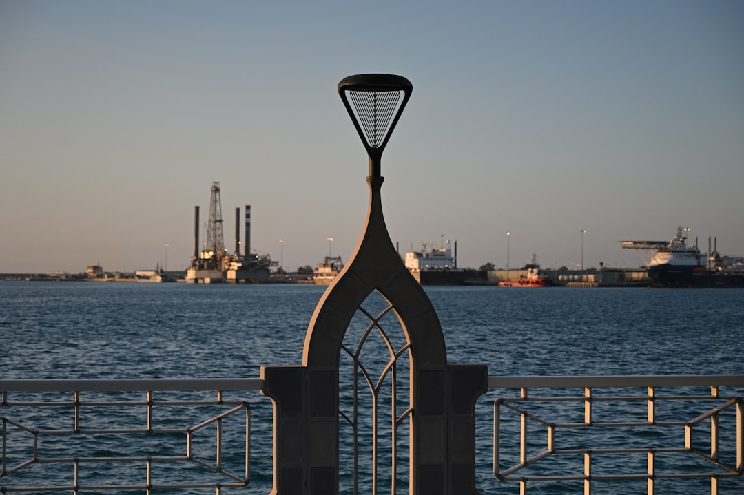 Harbor with industrial cranes and ships under clear sky.