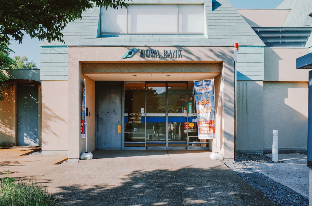 Modern bank entrance with glass doors and signage.