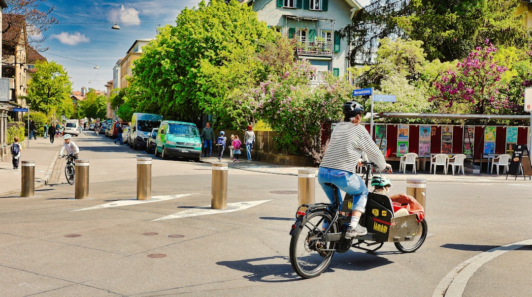 Person rides bicycle with child trailer on street