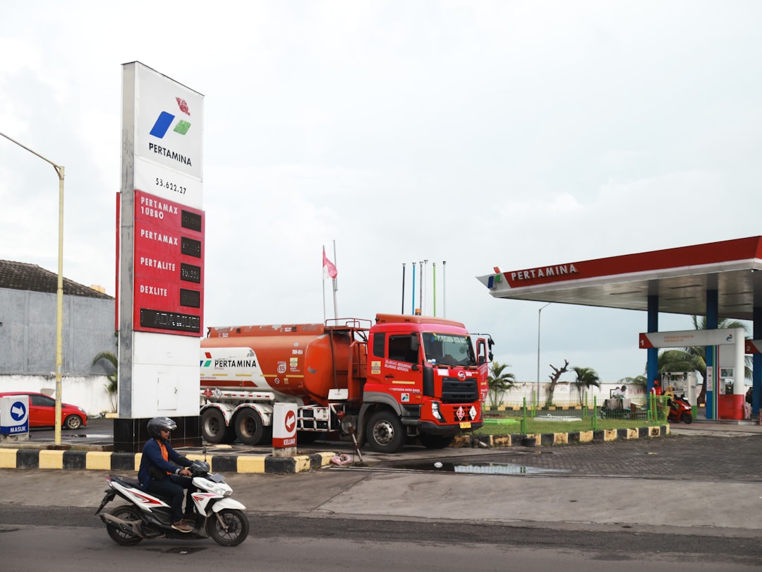 A red tanker truck at a gas station.