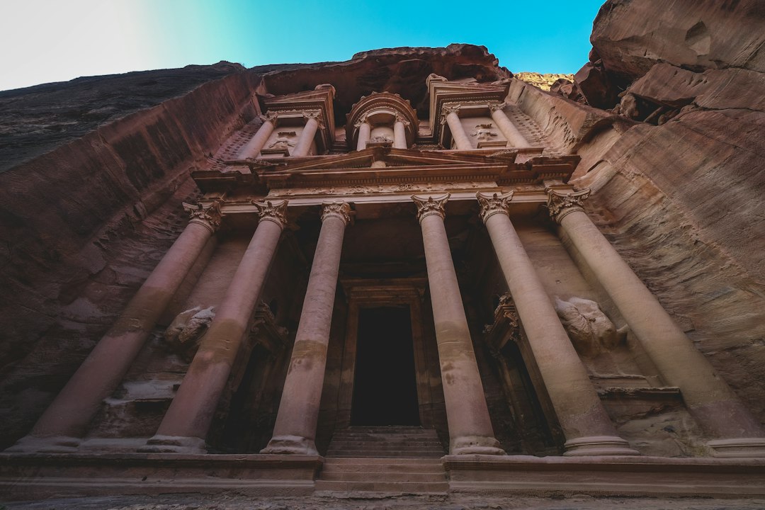 a tall building with columns and statues on the side of it
