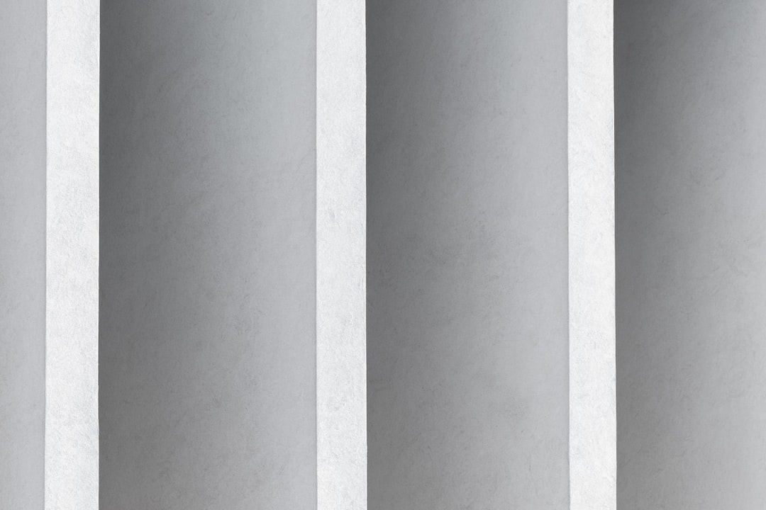 a man in a suit and tie standing in front of a wall