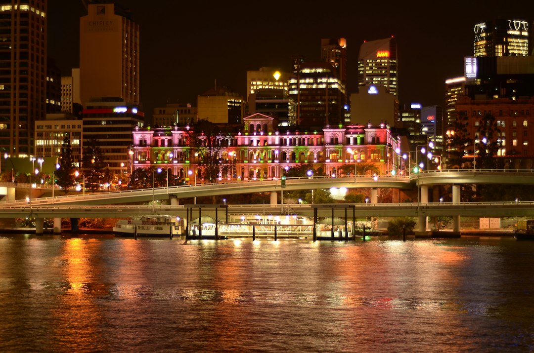 city buildings near body of water during night time
