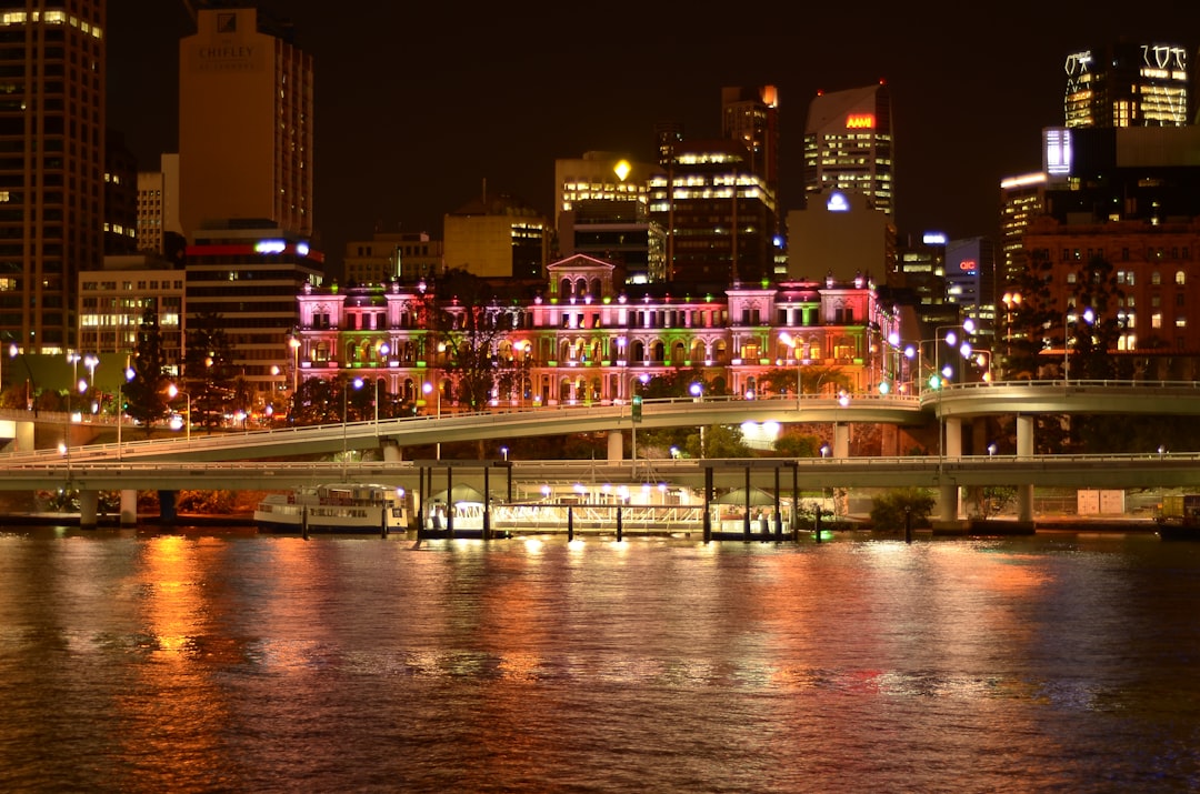 city buildings near body of water during night time