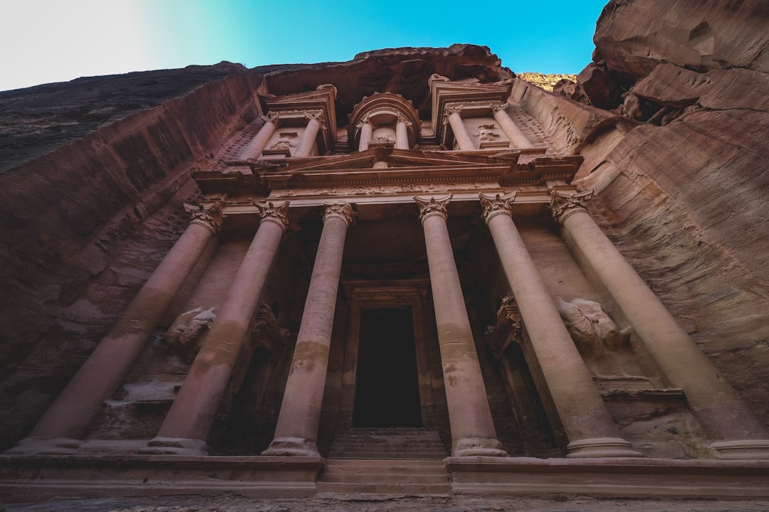 a tall building with columns and statues on the side of it