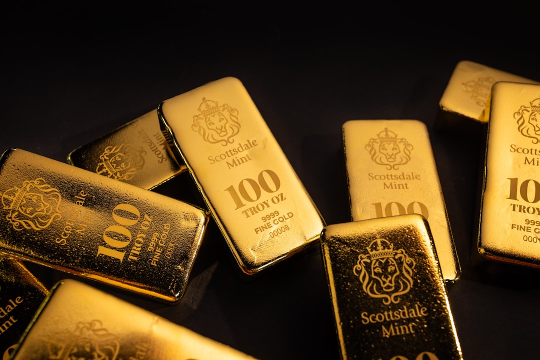 Several gold bars scattered on a dark surface.