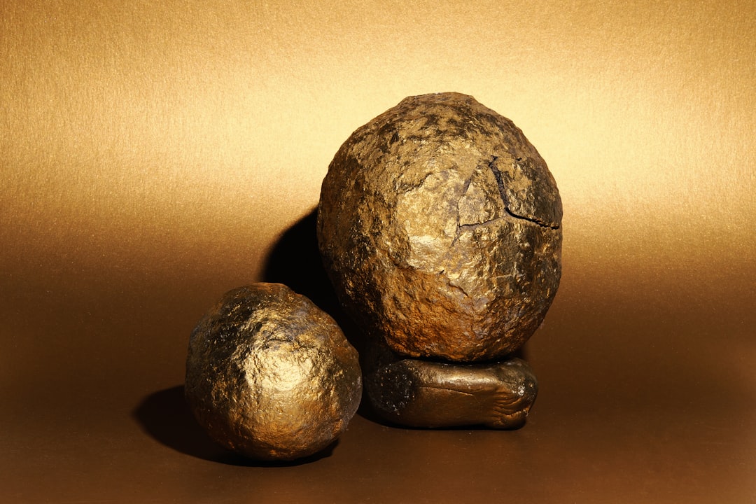 Two rough, golden objects on a golden background.