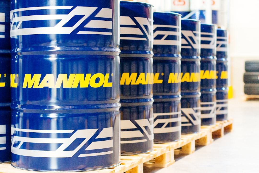 a row of blue barrels sitting on top of pallets