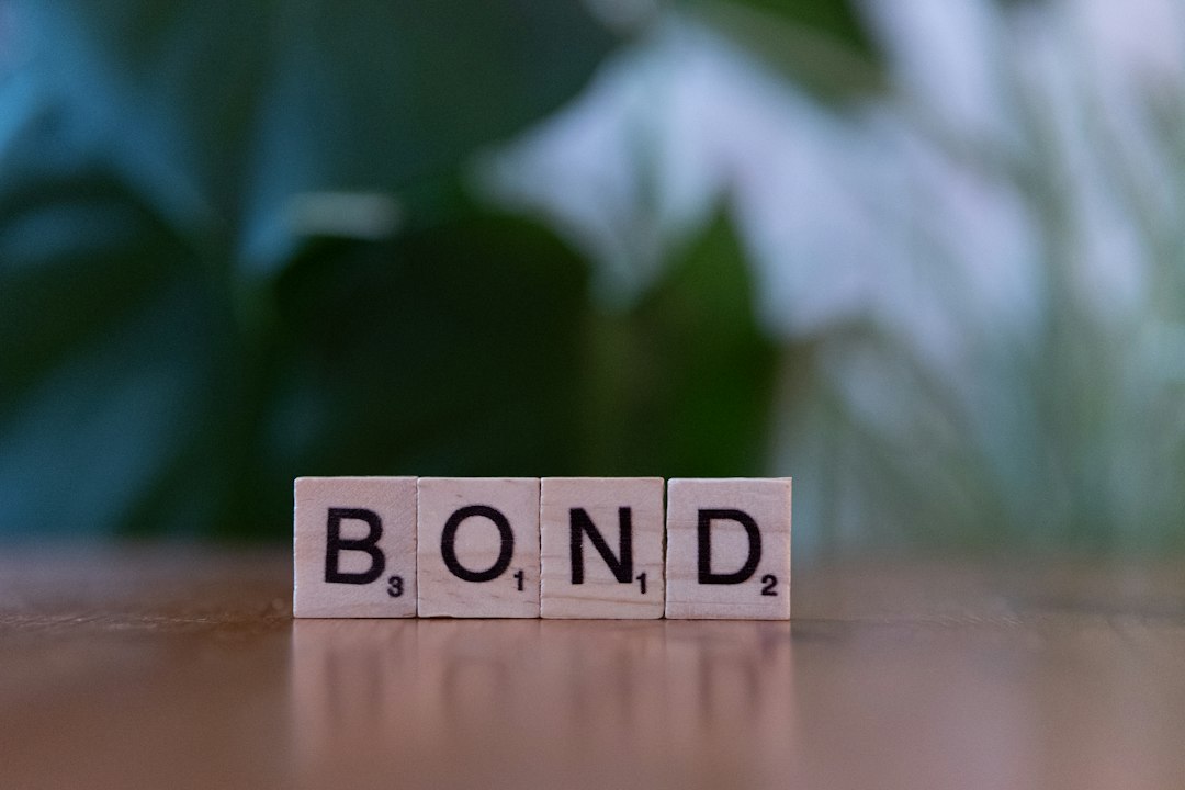 The word bond spelled with scrabble blocks on a table