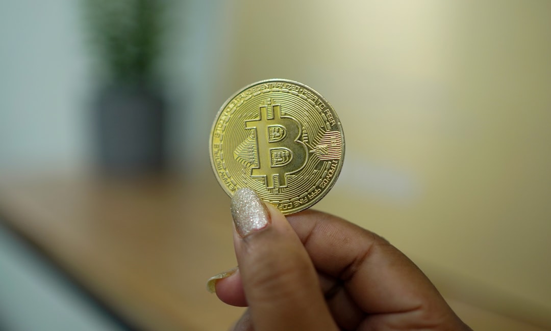 a hand holding a gold coin