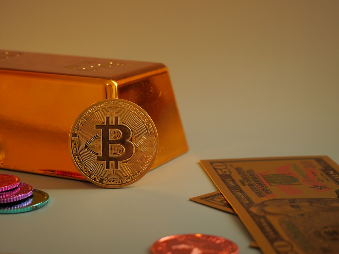 Bitcoin coin with gold bar and currency notes.