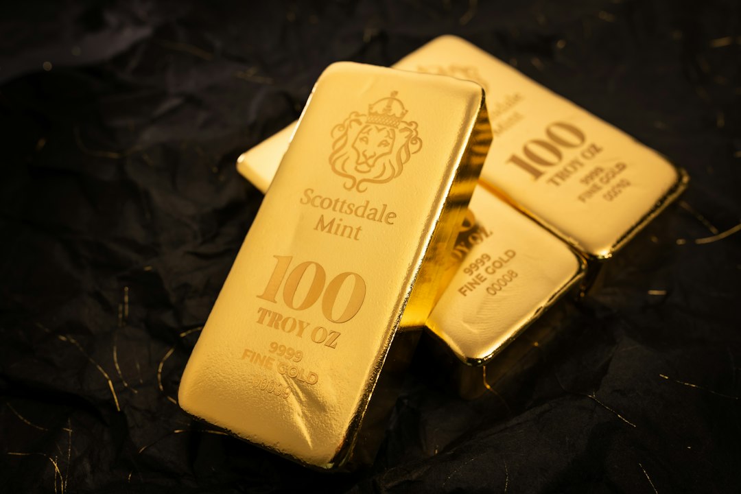 Several gold bars stacked on a dark surface