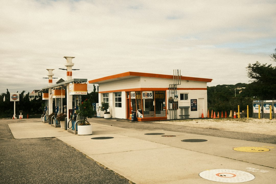 A vintage Gulf gas station with orange trim and fuel pumps under a canopy