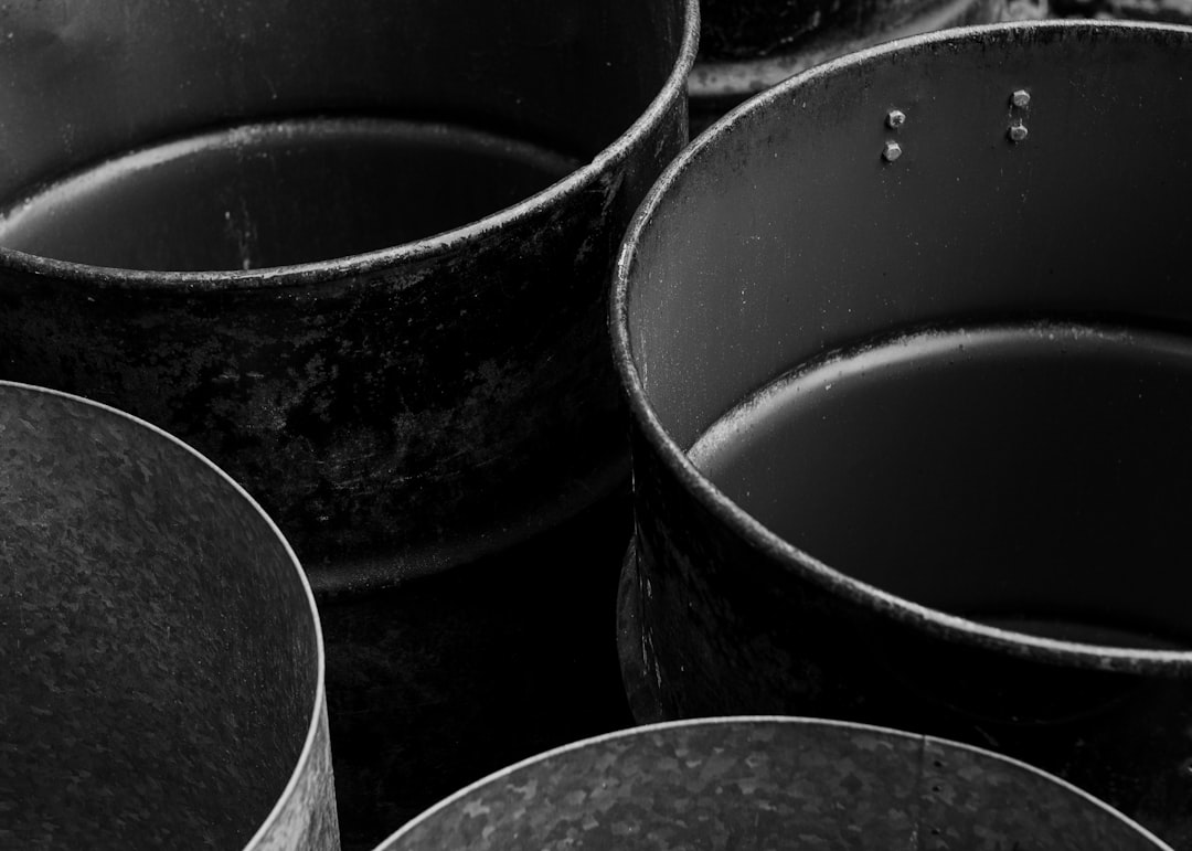 Old, empty metal containers are depicted in black and white.