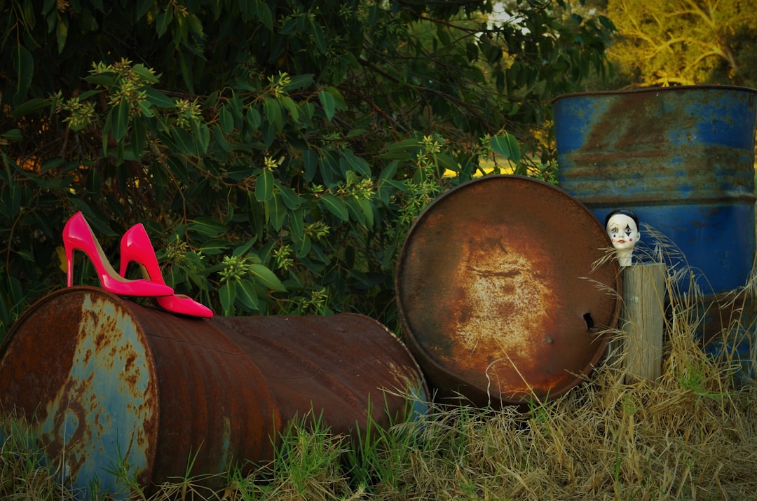 a pair of pink high heels sitting on top of a barrel