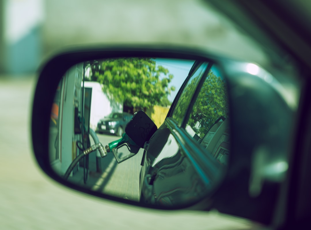 Fueling up the car from a side mirror's perspective.