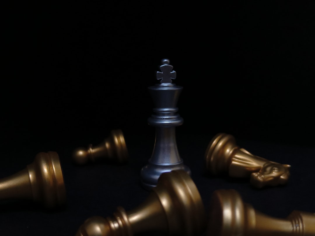 a silver and gold chess set on a black background