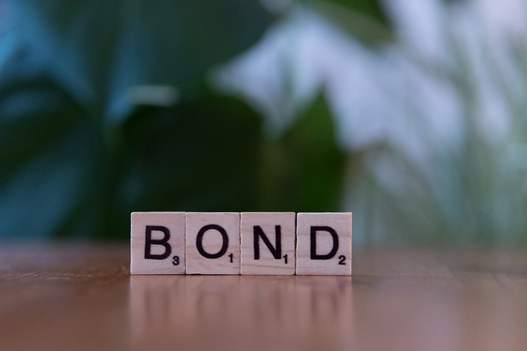 The word bond spelled with scrabble blocks on a table